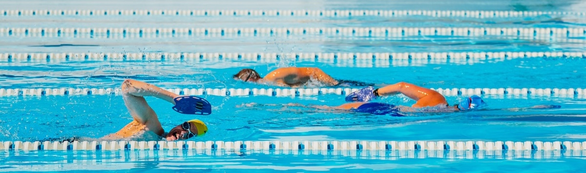 Person swimming front crawl stroke in open air pool
